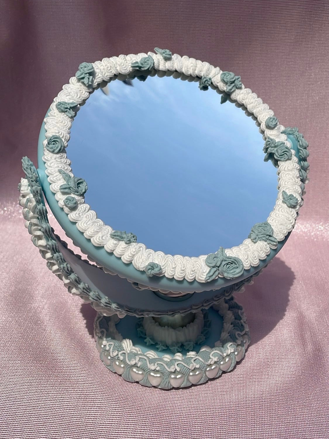 a circular table mirror decorated to look like a blue cake