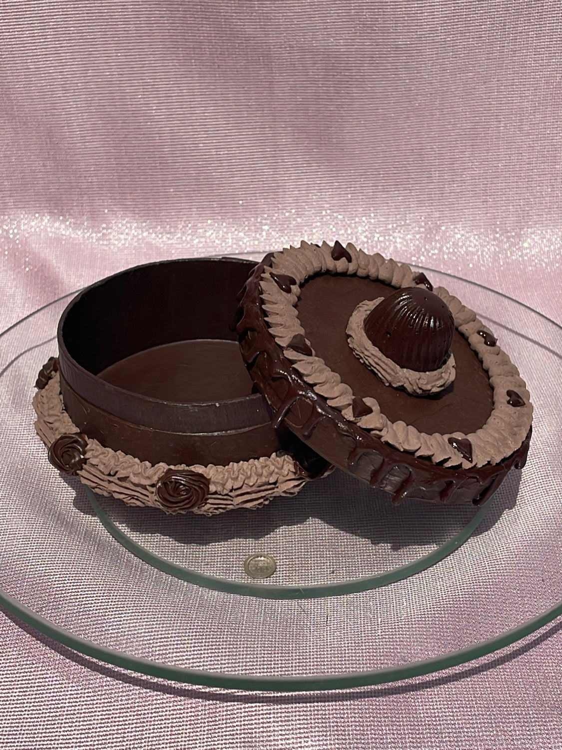 an opened round box decorated to look like a chocolate cake