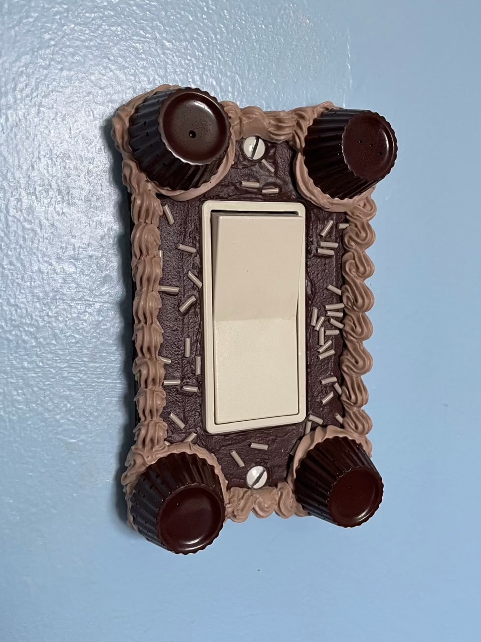 a light switch with a light switch plate decorated to look like a chocolate cake